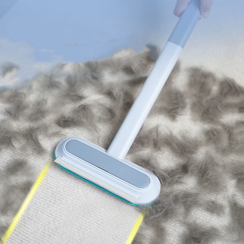 The brush being pulled across a carpet covered in loose pet hair.